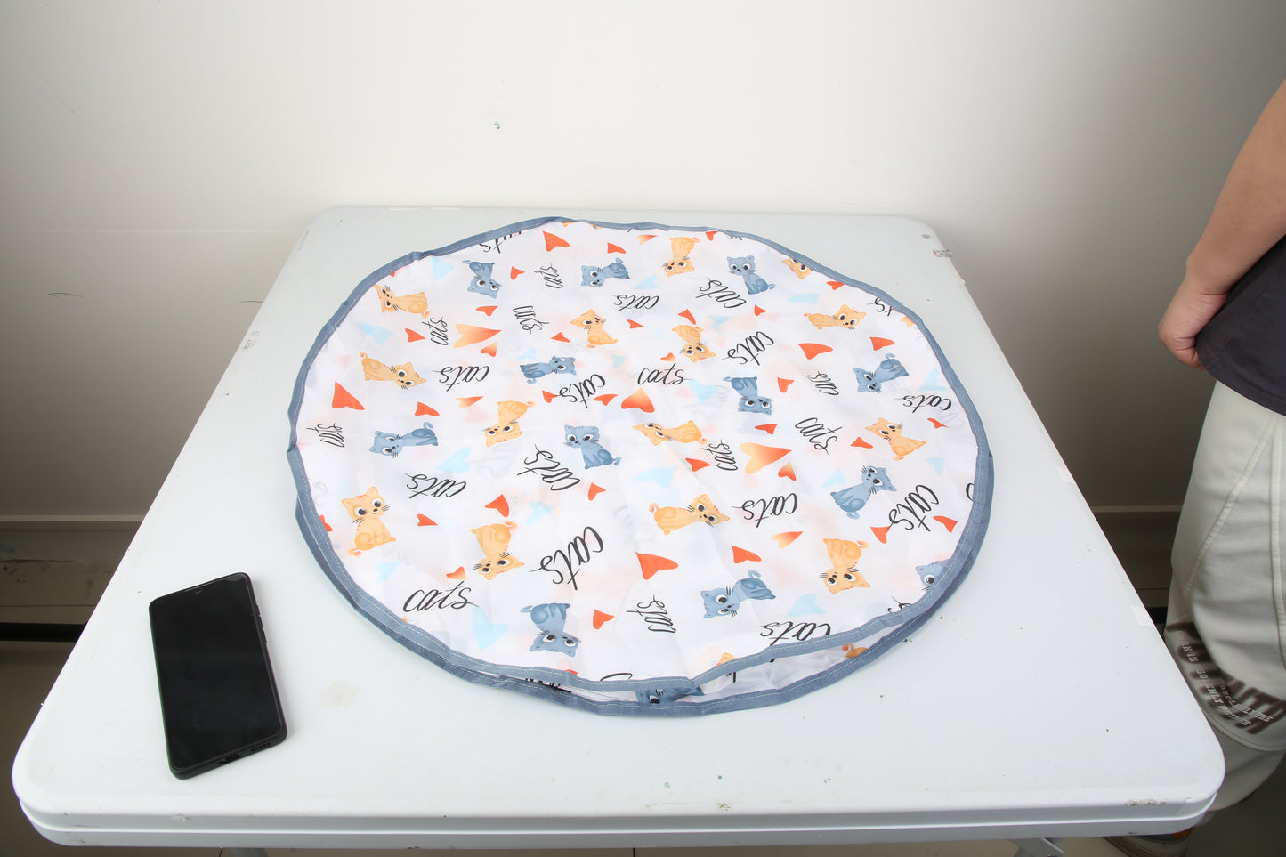 Round fabric mat with cat pattern on a white table